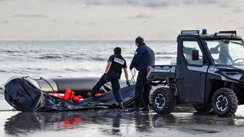 French National Police officers confiscate a boat after preventing migrants from boarding a smuggler's boat in an attempt to cross the English Channel, on the beach of Gravelines, near Dunkirk, northern France on 26 April 2024