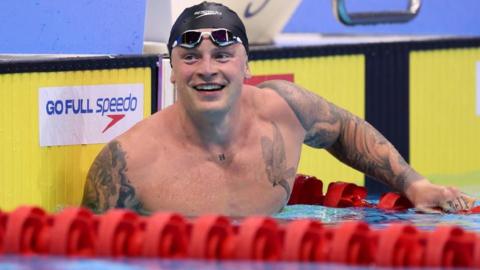 Adam Peaty smiles in the pool