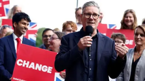 Labour Party leader Sir Keir Starmer speaks to supporters via a microphone during a general election campaign event before being elected prime minster