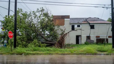 Getty Images A tree in Houston, Texas was toppled by Hurricane Beryl's fierce winds