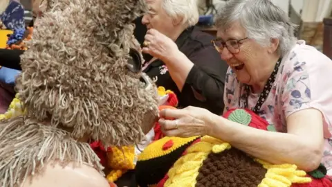 Ballet Lorent creative knitting group alongside their created props and costumes