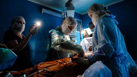 Doctors use phone lights to do surgery in Ukraine, November 2022