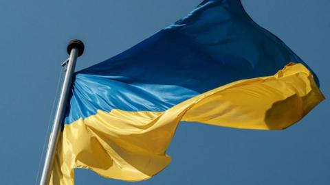 Ukraine flag with blue and yellow horizontal colours flying in the wind 