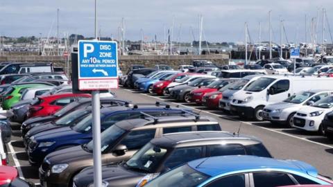 Cars in a car park with a 10-hour parking sign