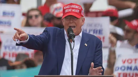 Donald Trump gesturing behind a lectern