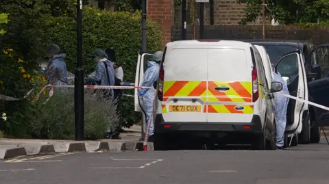 PA Media Police and forensic officers and at an address in Shepherd's Bush, west London, after human remains were found in two suitcases near the Clifton Suspension Bridge in Bristol