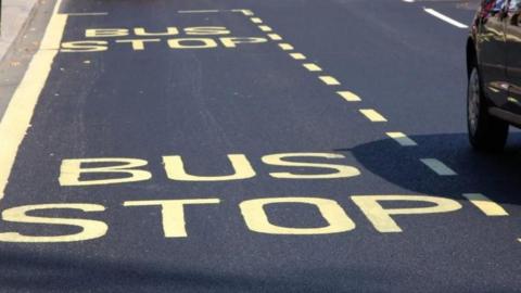 A car driving past a bus stop