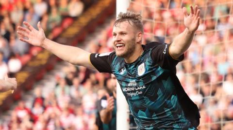 Elliott Nevitt celebrates scoring for Crewe