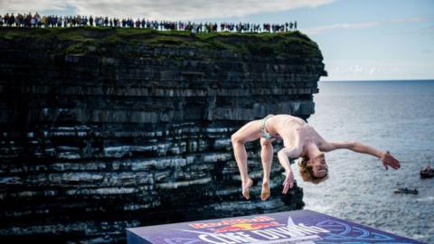Gary Hunt of France backflips in reaction to the crowd, prior diving from the 27.5 metre platform during the final competition day of the fourth stop of the Red Bull Cliff Diving World Series on September 12, 2021 at Downpatrick Head, Ireland