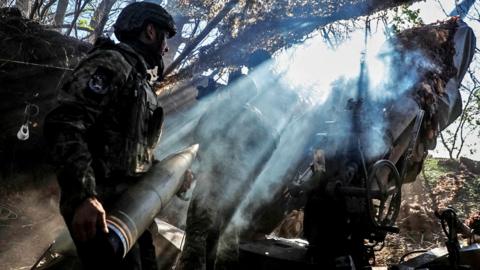 Ukrainian soldiers use a Howitzer