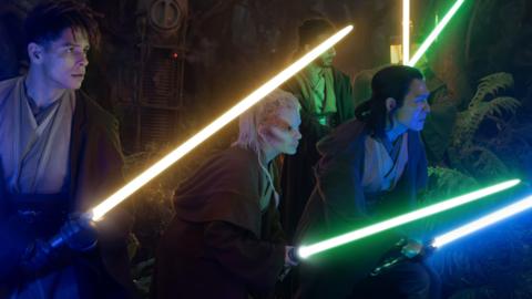 A group of Jedi stand with their lightsabers ignited.