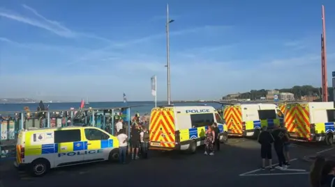 Police vans parked in front of Weymouth seafront.