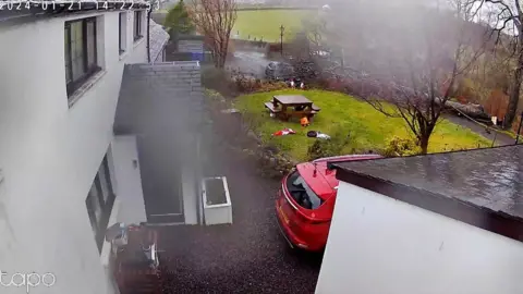 A tree falls on a black car in Lochwinnoch.