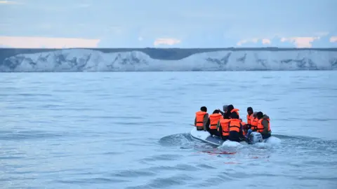 Getty Images Migrants in a dinghy sail in the Channel toward the south coast of England