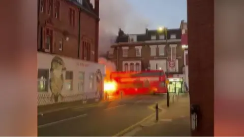 Red double-decker bus on fire