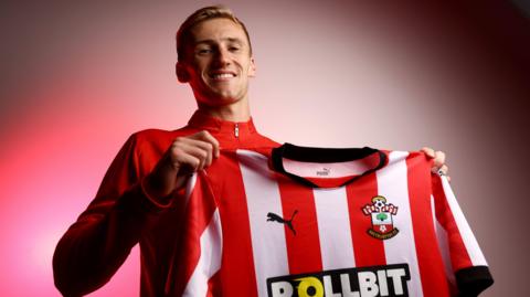 Flynn Downes poses with Southampton shirt after joining on a permanent deal from West Ham