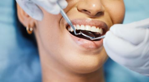 Close up of hands holding dentistry tools in patient's mouth