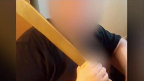 A still from a video, filmed by Beth, showing the agent attacking her with a machete