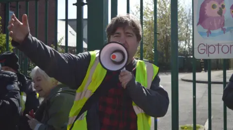 Family handout / Tanis Belsham-Wray Campaigner Iain Dalton with a megaphone at a Save Little Owls nurseries protest