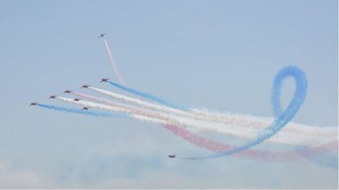 The Red Arrows fly with streams of coloured smoke coming out behind them at a previous Jersey International Air Display