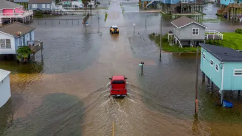 Truck drives through flooding in Surfside, Texas