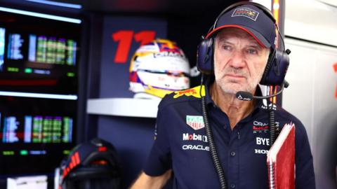 Adrian Newey holds his notebook in the Red Bull garage 