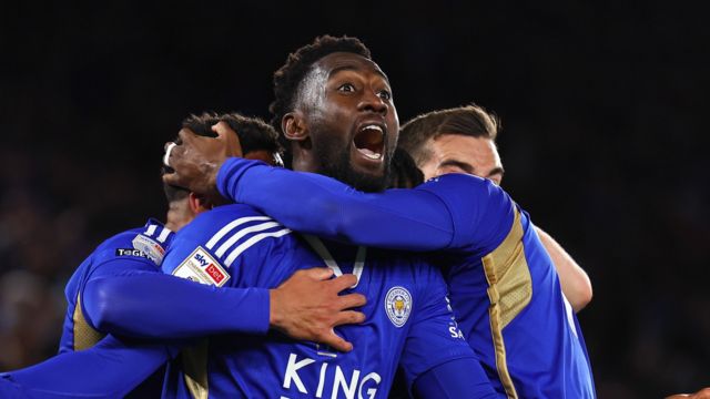 Wilfred Ndidi shouts as he is mobbed by Leicester players, wearing blue, after scoring a goal