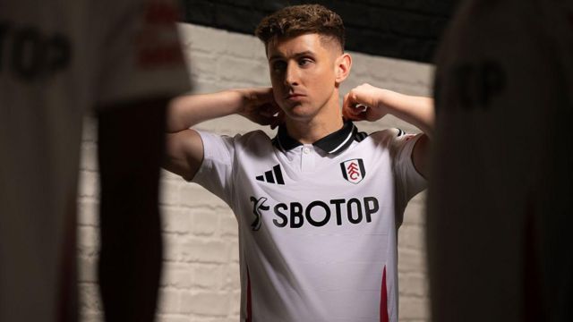 Tom Cairney models Fulham's new home shirt