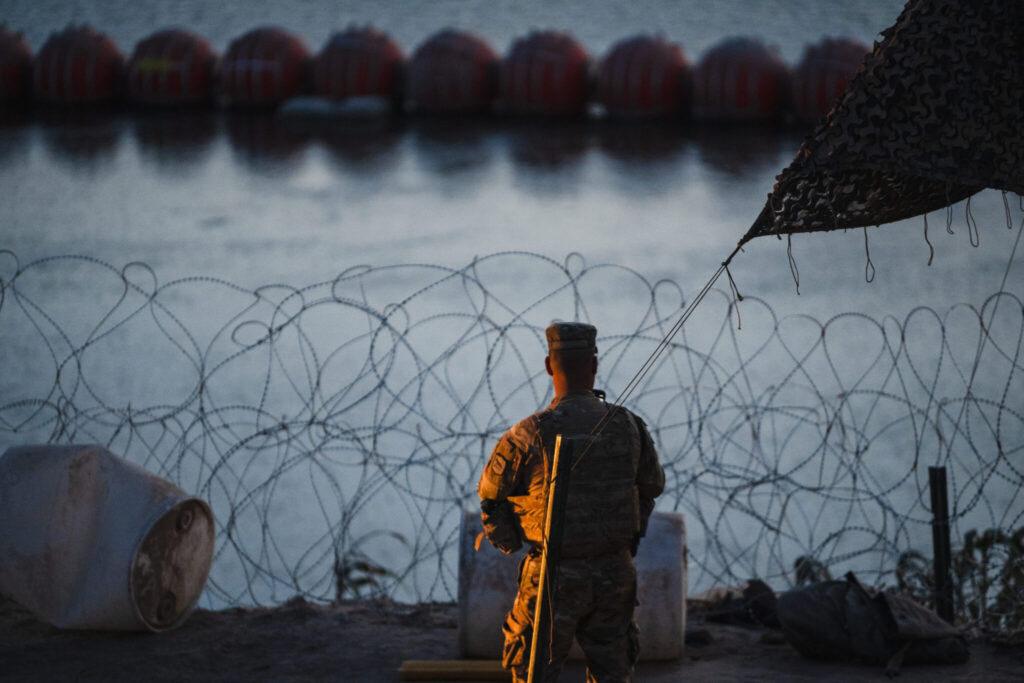 soldier with the South Dakota National Guard stands near the banks of the Rio Grande in Eagle Pass, Texas,