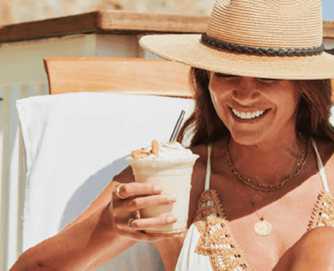 Lady enjoying a milkshake while lounging on a sunbed near Catalina Island Company