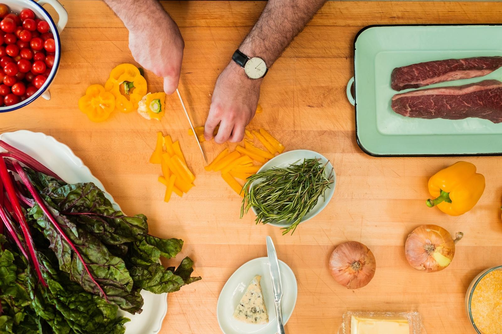 Man chops carrots on kitchen countertop