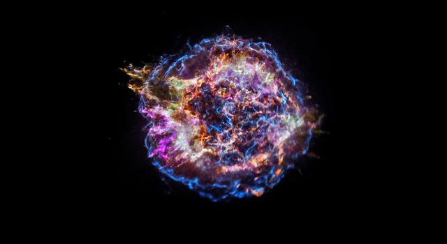 The supernova remnant of Cassiopeia A appears as an explosion of colors against the blackness of space.