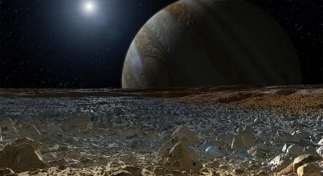 Jupiter takes up most of the sky beyond the blue and brown horizon of Europa's icy surface in this simulated view from Jupiter's moon.