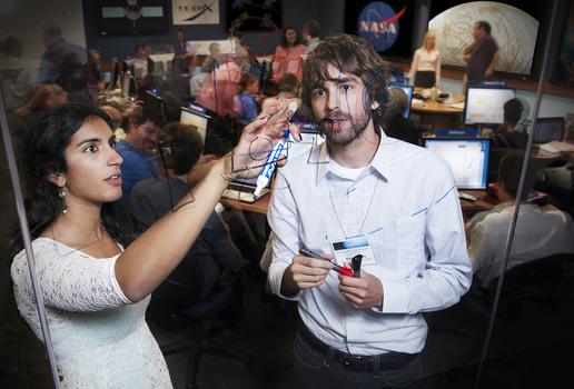 Students write on a glass panel inside the Team X room at JPL