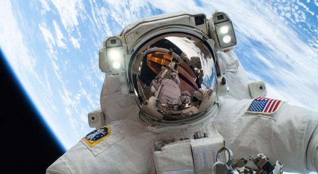 NASA astronaut Mike Hopkins in a spacesuit with the Earth behind him