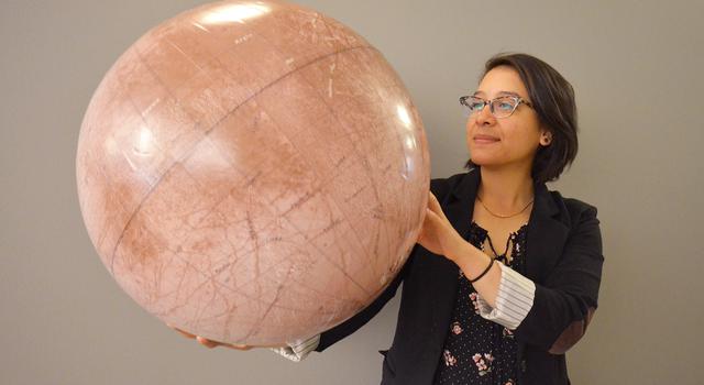 JPL intern Kathy Vega poses with a model of Jupiter's moon Europa