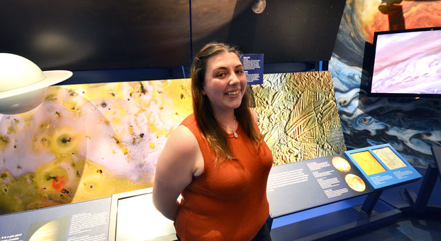 JPL intern Maya Yanez stands in front of the Jupiter display in the lab's museum