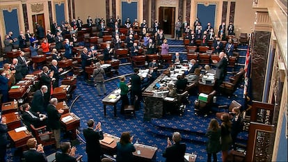 Senadores aplaudem o resultado da votação do plano de resgate, neste sábado, em Washington.