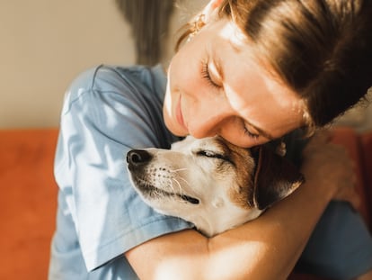 Una mujer abraza a su perro.