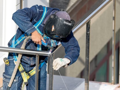 Un soldador, durante el montaje de una barandilla en la construcción de unas viviendas. EFE/Luis Tejido