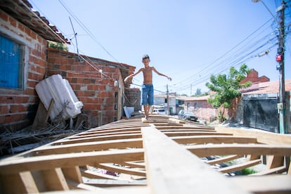 O neto do pescador Antônio Banqueiro caminha sobre o esqueleto da jangada que está sendo construída pelo avô na rua onde moram, no morro Santa Terezinha. Os pescadores já não vivem em palhoças na beira do mar, mas foram empurrados para casas de alvenaria em morros onde enfrentam também a violência das grandes cidades e o poder do tráfico de drogas.