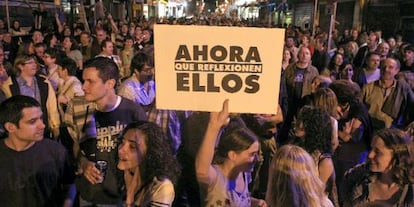 Uma jovem mostra um cartaz em rua próxima à praça Sol, durante o 15-M.