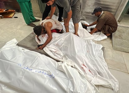 Un hombre llora sobre el cadáver de un familiar en un hospital de Gaza.