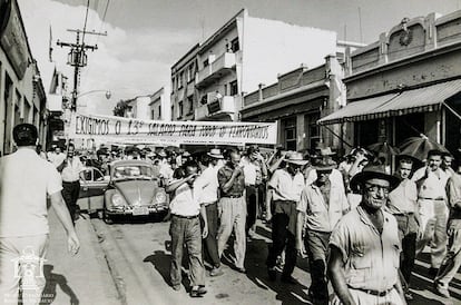 Fotografia com imagem de ferroviários da NOB em greve em passeata pela rua Primeiro de Agosto em Bauru SP, em uma das faixas lê-se: Exigimos o 13º salário para todos os ferroviários.