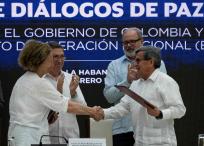 Vera Grabe (i), representante del gobierno, y Pablo Beltrán (d), del Eln, se dan la mano tras firmar la prórroga del cese el fuego en Cuba.