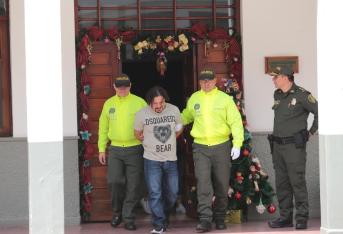 Hombres de la Policía trasladan a Tom tras su detención