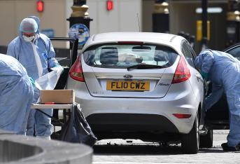 Oficiales forenses examinan el coche que chocó contra las barreras del Parlamento británico en Londres (Reino Unido). Un conductor arrolló  a varios ciclistas y peatones antes de chocar contra las barreras de seguridad del Parlamento británico.