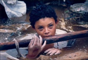 La tragedia de Armero ocurrió el 13 de noviembre de 1985. Hoy, a 33 años de una de las catástrofes naturales más lamentables del país, se mantienen vigentes algunas fotografías que le dieron la vuelta al mundo. La destrucción de este municipio del Tolima se presentó a causa de la erupción del Volcán Nevado del Ruiz, a las 11:30 p.m., cuando todos los habitantes esperaban conciliar el sueño dentro de sus casas, las cuales fueron arrasadas por el material que expulsó uno de los colosos naturales más reconocidos de Colombia. Omayra Sánchez, la niña de 13 años que aparece en la foto, cubierta de los escombros de su propio vecindario, siempre será recordada por la tenaz lucha que libró para sobrevivir, para no claudicar, para no desfallecer. Esta icónica imagen fue retratada por el francés Frank Fournier –‘La agonía de Omayra Sánchez’- momentos antes de la muerte de Omayra, ocurrida 3 días después del deslizamiento –el 16 de noviembre de 1985 se apagó la luz de la niña que cantaba esperando su rescate-.