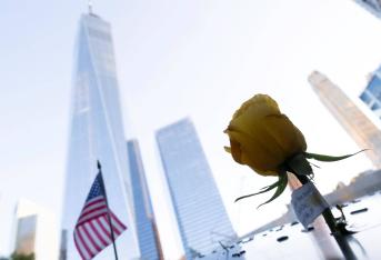 Una flor y una bandera ubicados en la piscina sur del "9/11 National Memorial", el monumento ubicado en los cimientos de las Torres Gemelas destruidas por los atentados del 11 de septiembre en Nueva York.