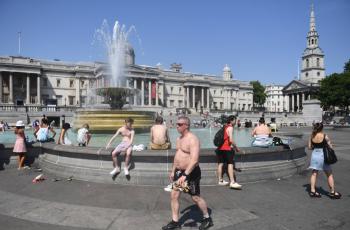 La gente se refresca junto a una fuente en Trafalgar Square, en Londres.